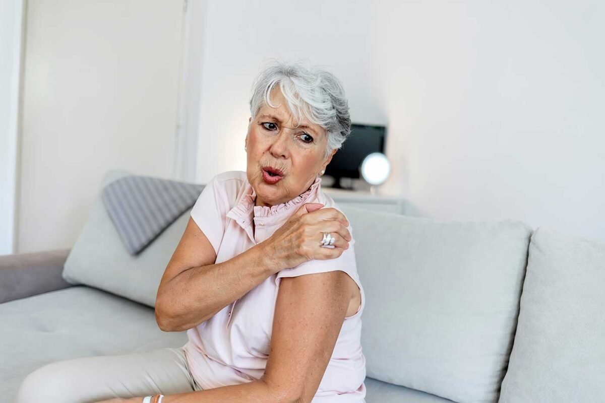 mulher idosa com dor no ombro bursite